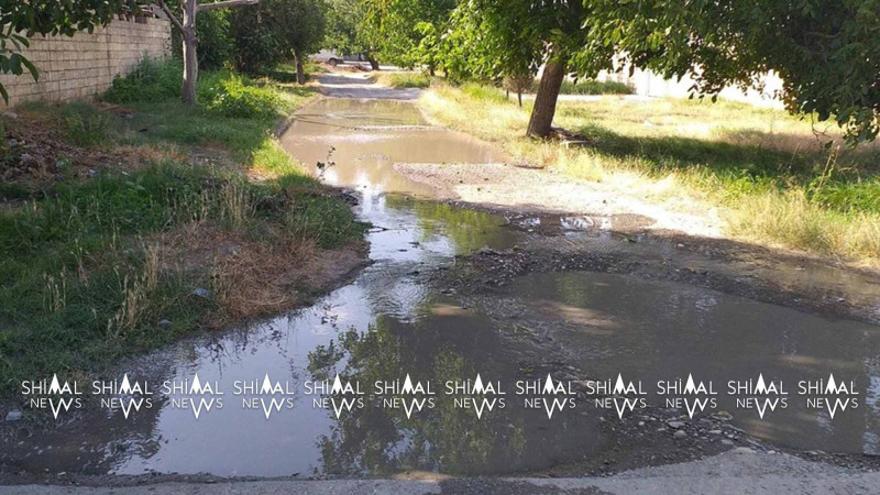 Qubada yola axan su yeni salınmış asfaltı zədələyir
